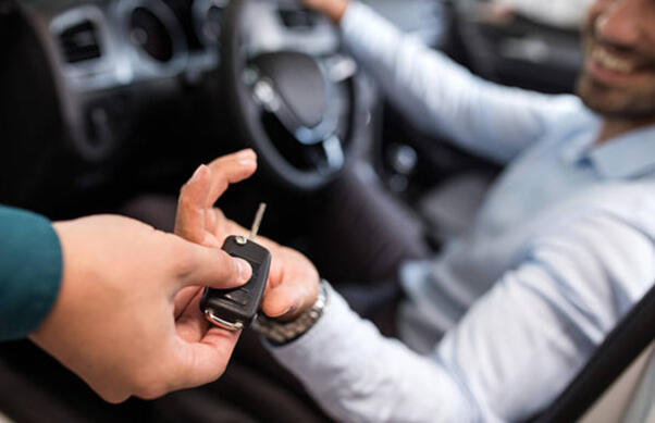 Car Rental Key Handover A rental agent handing car keys to a customer, symbolizing the start of a car rental experience.